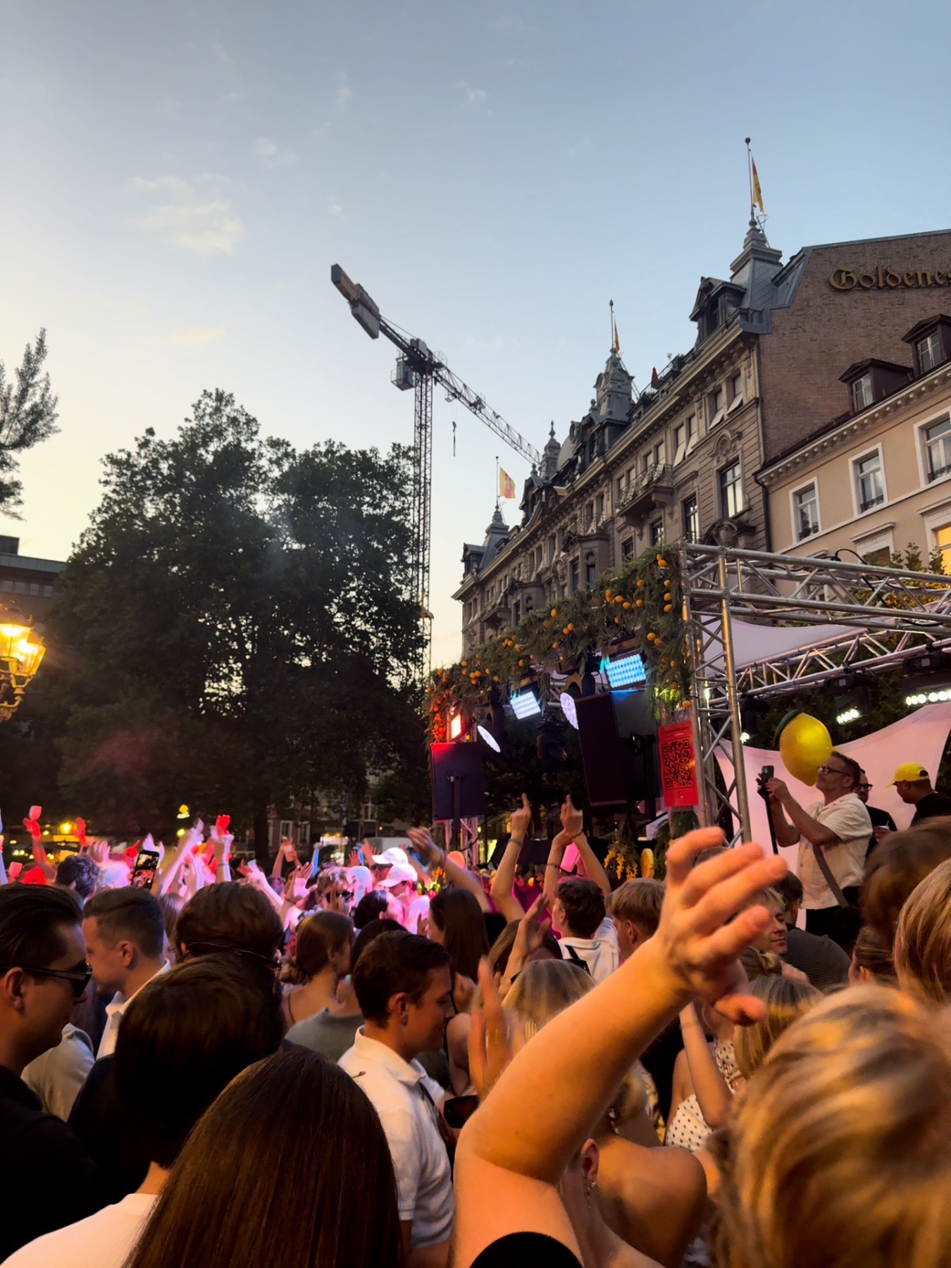 Feiernde Menge vor der Bühne bei einem Open-Air-Event in der Abenddämmerung