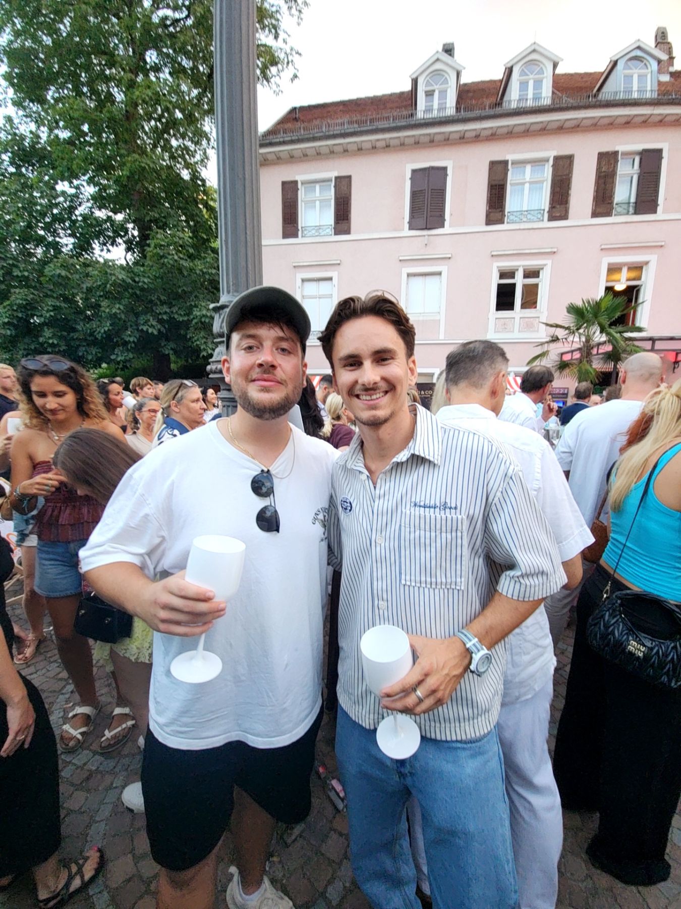 Zwei Gäste mit Getränken bei einem sommerlichen Straßenfest